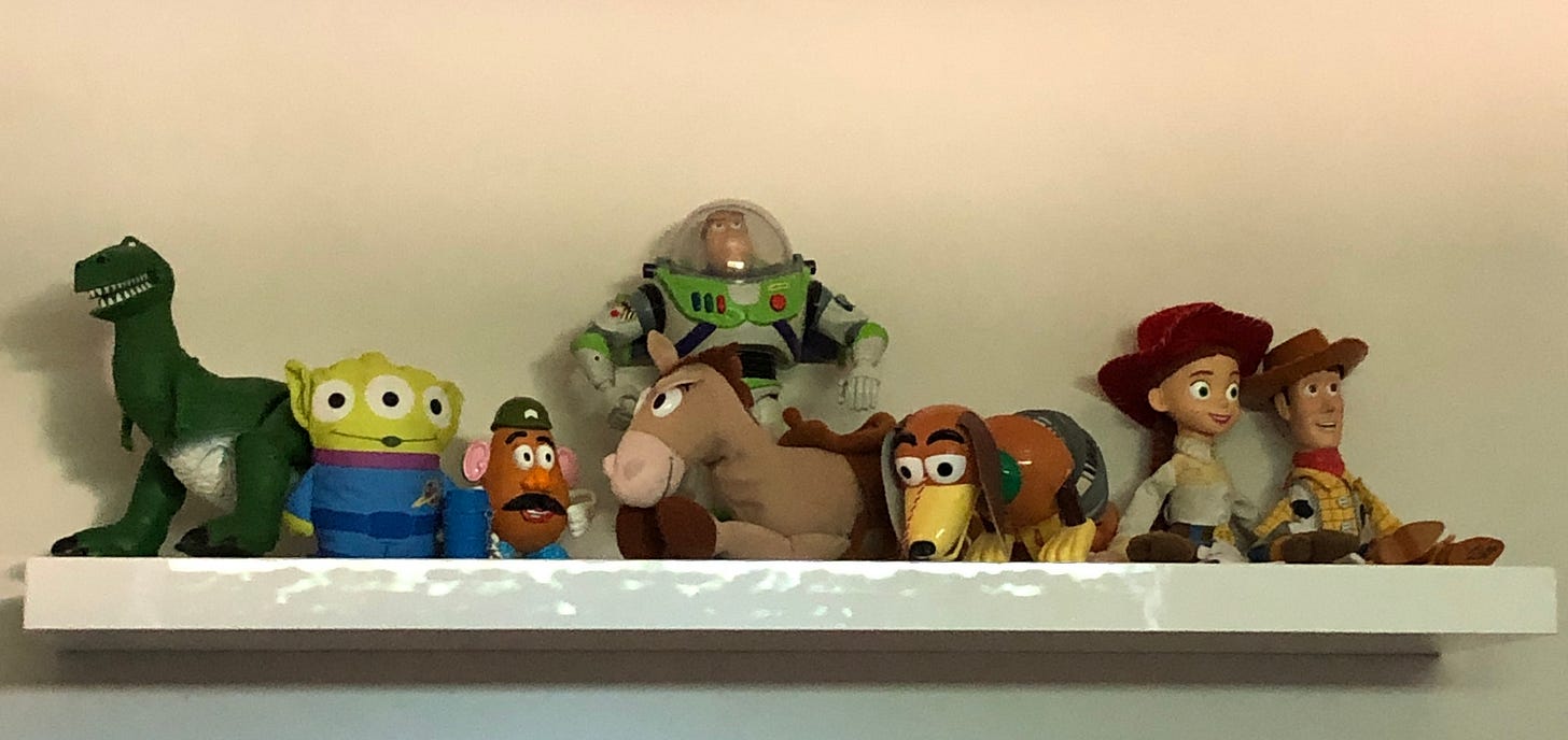 Toy Story figures hanging out on a white floating shelf.