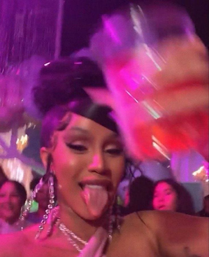 This may contain: a woman sticking out her tongue at a party