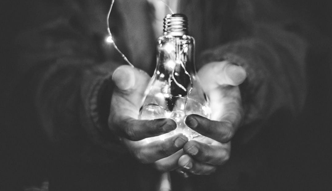 man holding incandescent bulb man holding incandescent bulb