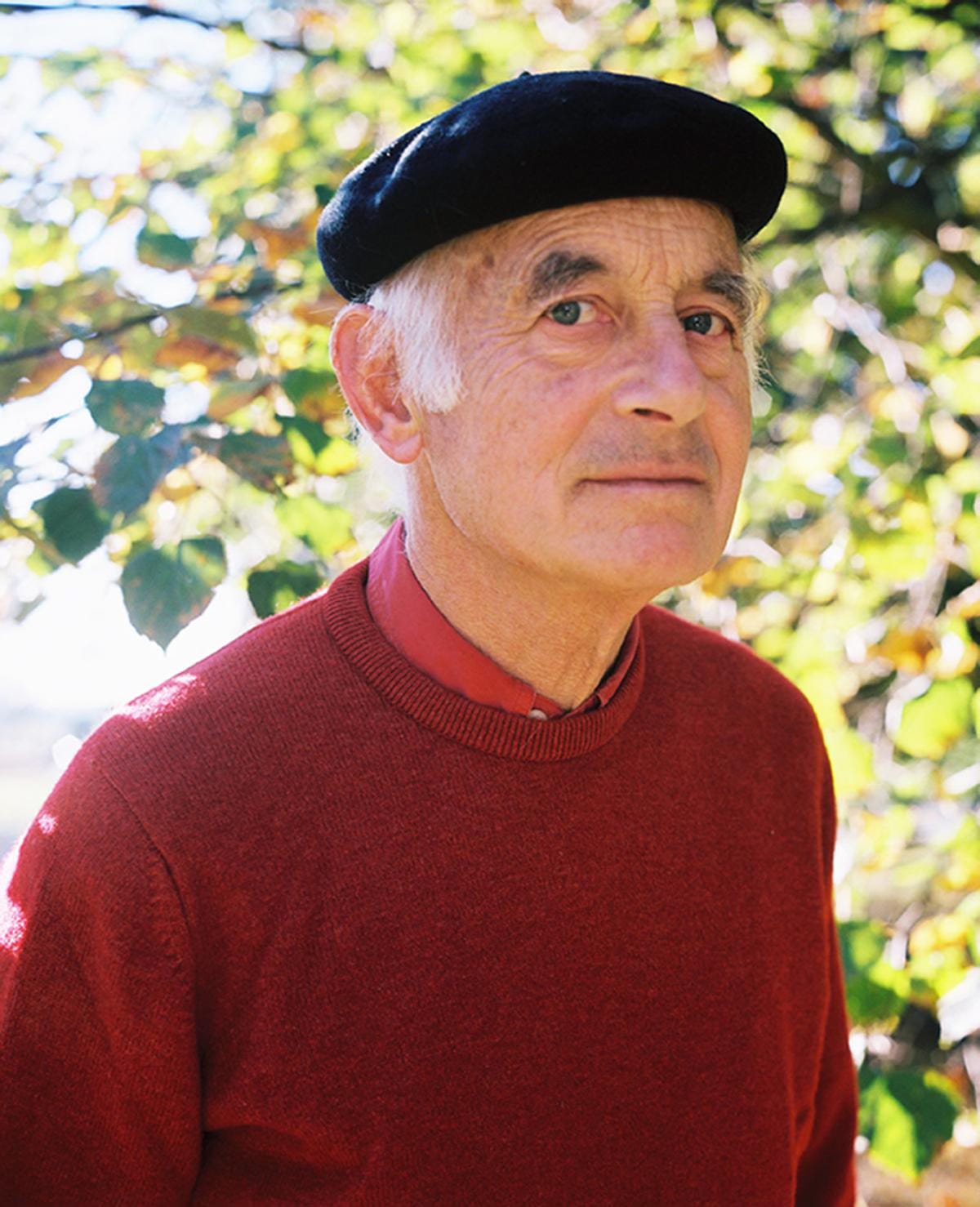 Photograph of Michael Laskey in a red jumper and black beret.