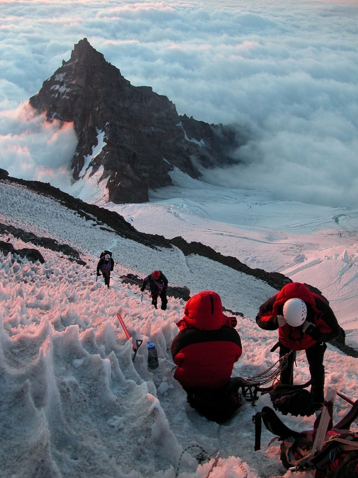 Climbers ascending Mount Rainier with Little Tahoma Peak visible in the background, United States.