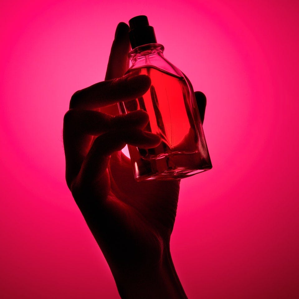 a hand holding a perfume bottle