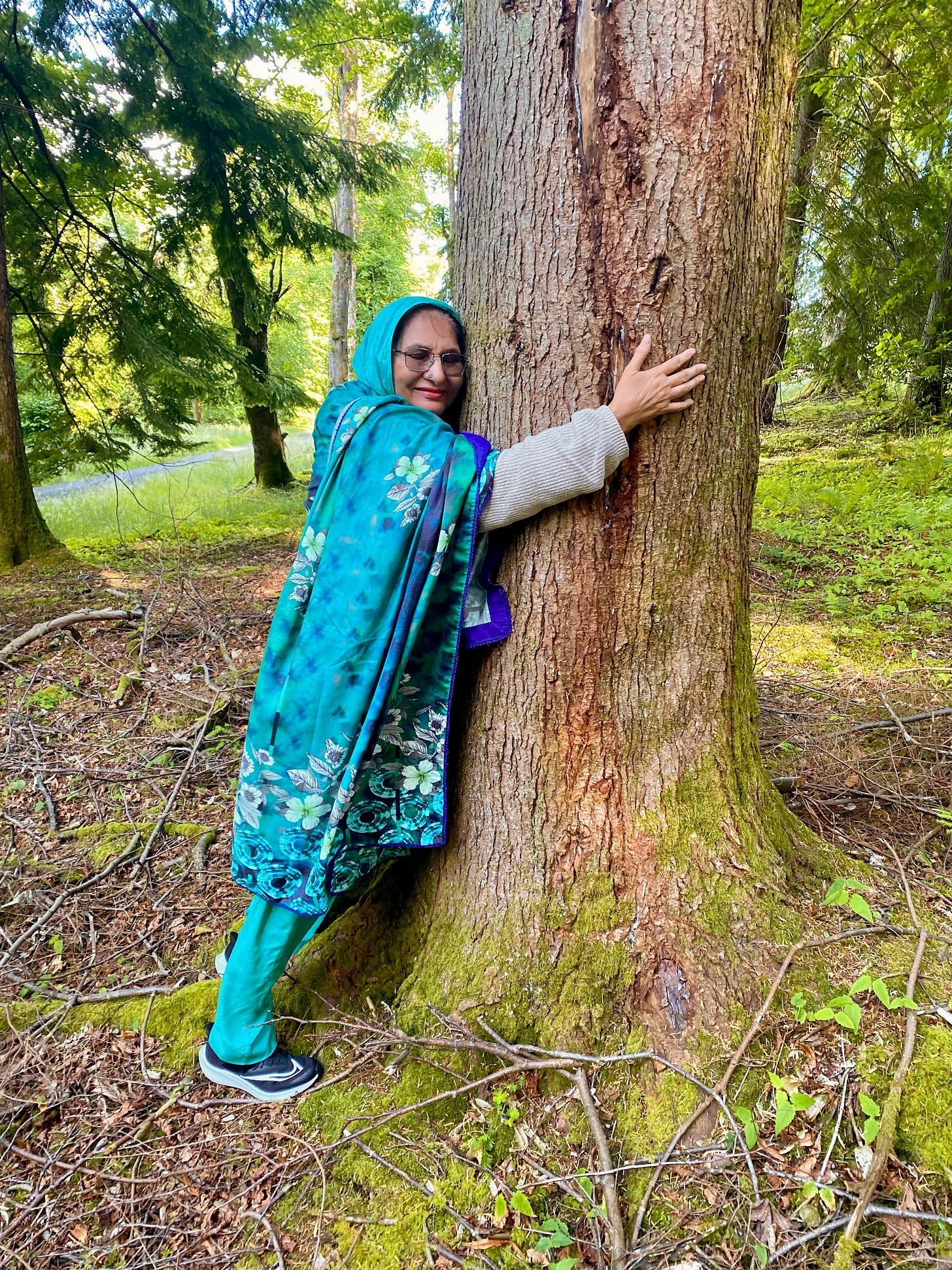 Sulaiman's Mama hugging a tree in a forest in Scotland.