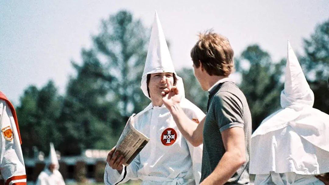 Artist Bruce Larsen confronts a Ku Klux Klan member at an Alabama rally in 1986, making a defiant gesture while stating, 'This is America and it is for everybody.' Artist Bruce Larsen confronts a Ku Klux Klan member at an Alabama rally in 1986, making a defiant gesture while stating, 'This is America and it is for everybody.'