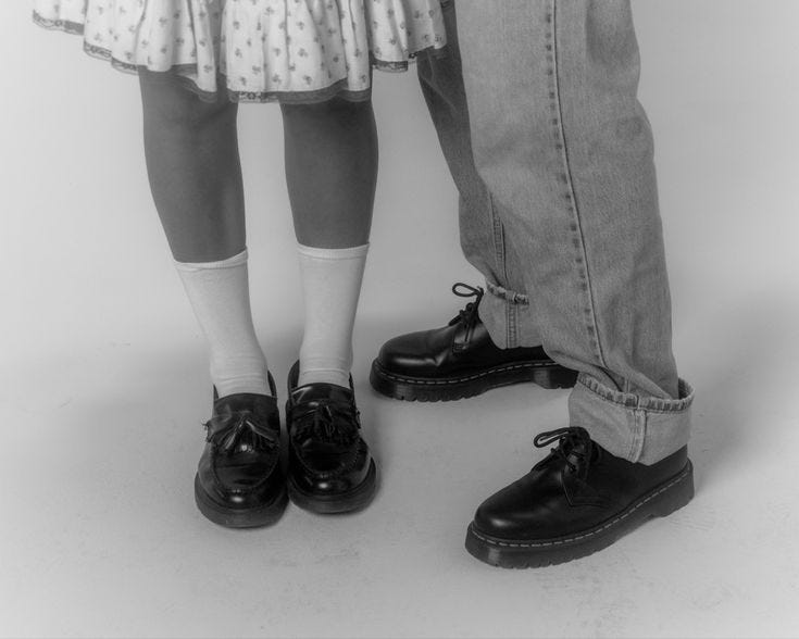 This may contain: two people standing next to each other wearing shoes