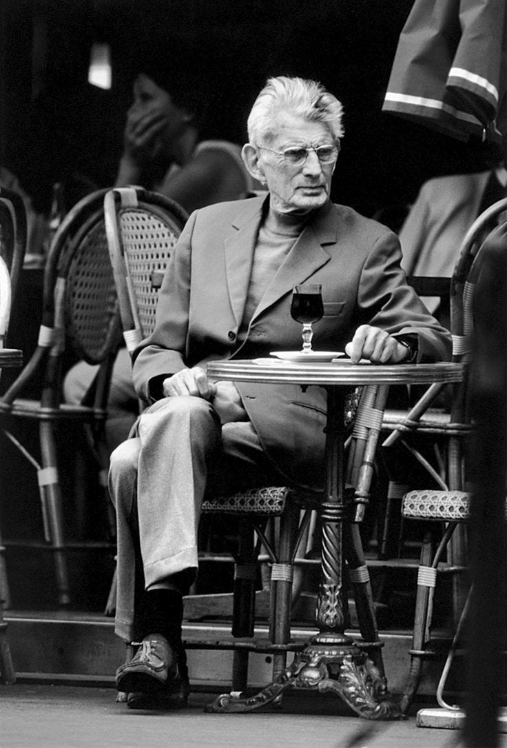 This may contain: black and white photograph of an older man sitting at a table