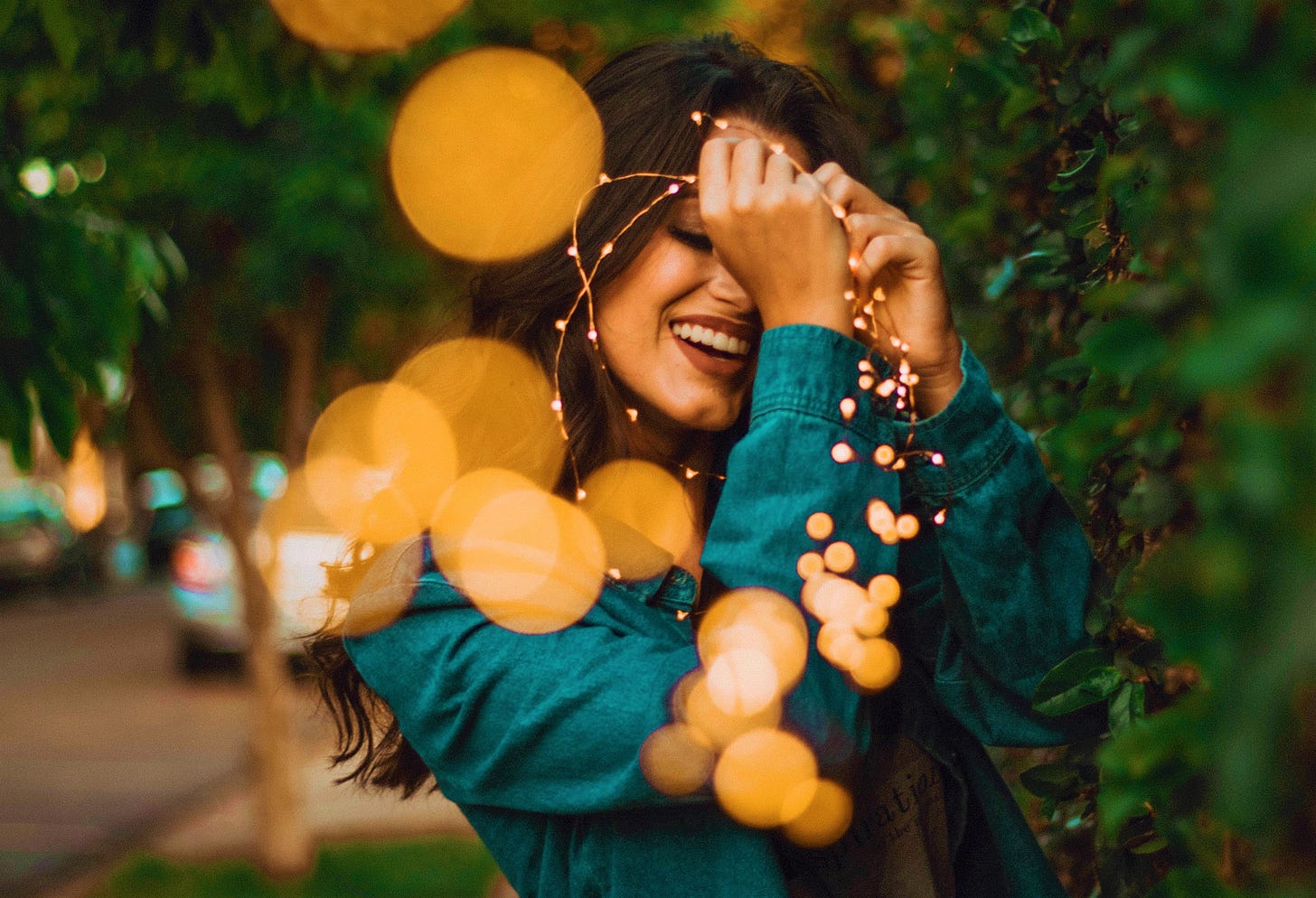 happy girl holding string of lights
