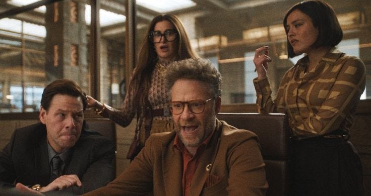 This may contain: three women and one man are sitting at a table