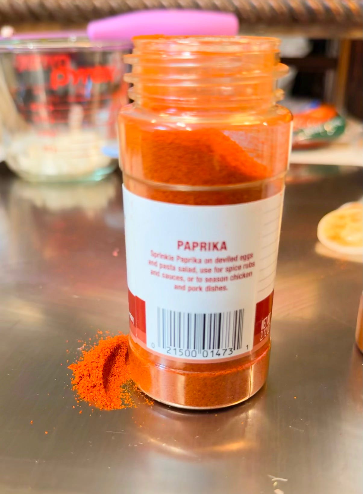 Open bottle of paprika with paprika spilled on the counter in a soul food kitchen, photographed for The Soul Food Pot® Juneteenth post about red foods, Black folks' potato salad, and cookout recipes
