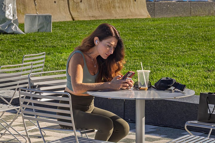 Four Seaport candids: people resting on granite blocks, a dock worker, a woman with her dog, and a woman at a table on the lawn