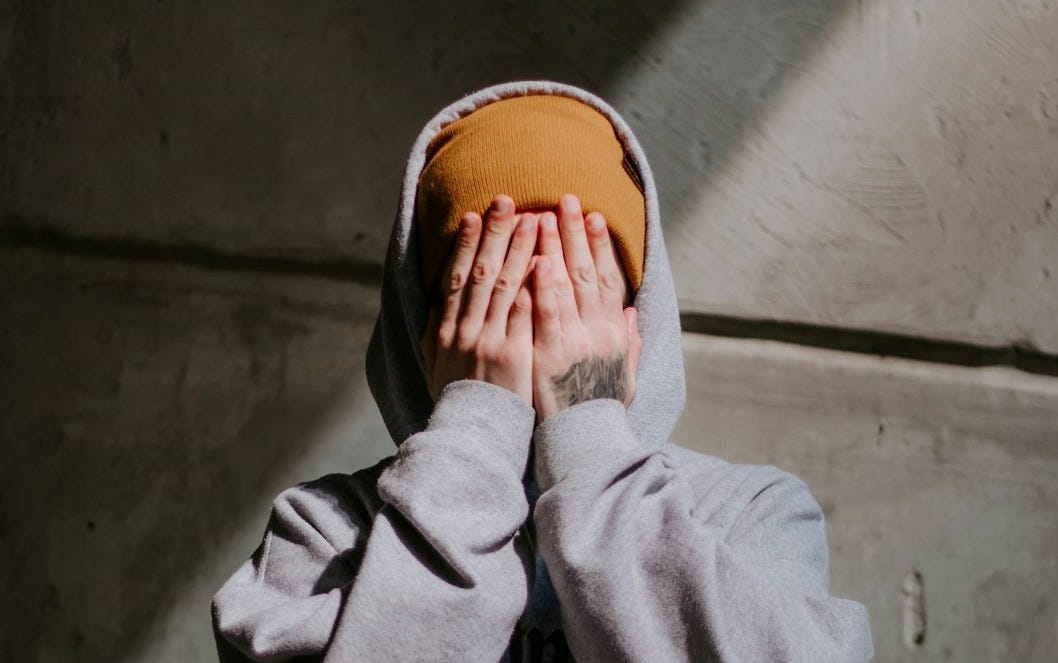 person in gray hoodie wearing brown leather shoes