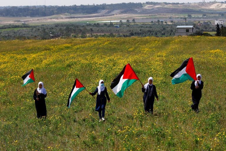Palestinians hold flags as they mark 'Land Day', an annual commemoration of six Arab citizens of Israel who were killed by Israeli security forces during demonstrations over land confiscations in 1976, in the southeast of Gaza City March 30, 2023. REUTERS/Ibraheem Abu Mustafa   TPX IMAGES OF THE DAY