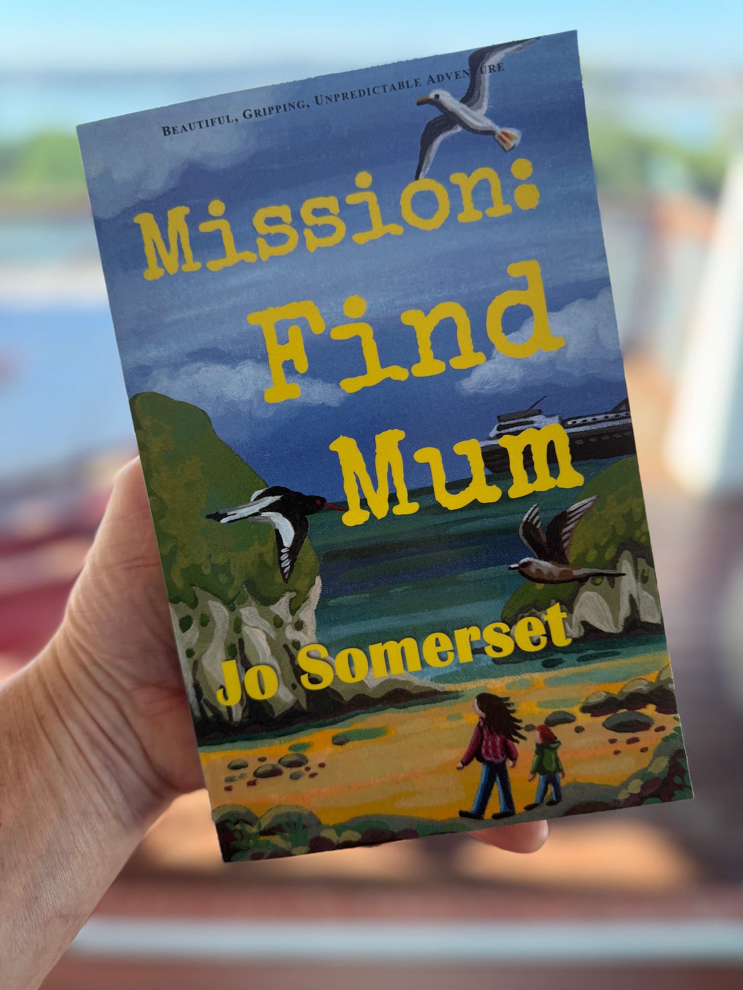 Man holding a copy of Mission: Find Mum Man holding a copy of Mission: Find Mum