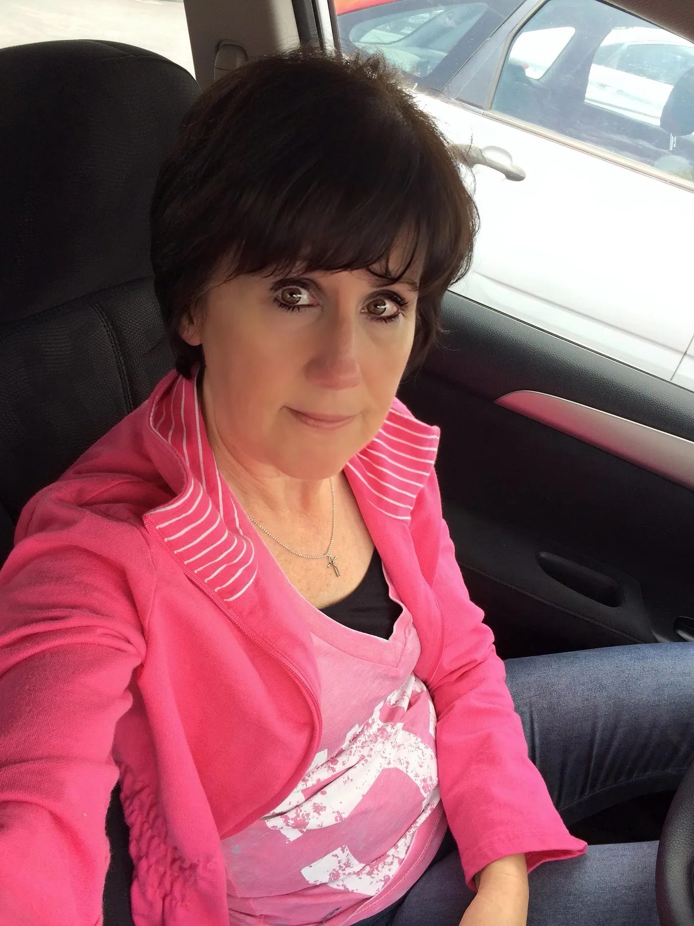 A crying woman selfie in the car after she had her hair cut short because she had cancer.