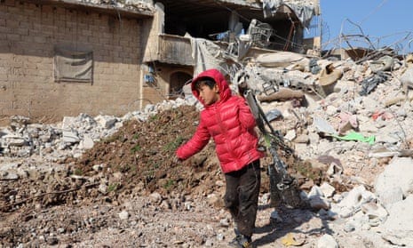 A child salvages a bicycle from the ruins of a building, in the town of Jindayris, in Syria's Aleppo province, on 10 February.