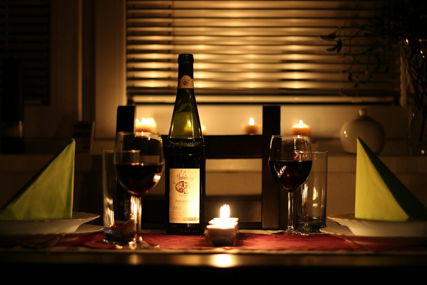 Une table avec verre à vin et bouteille de rouge et bougies. Une table avec verre à vin et bouteille de rouge et bougies.