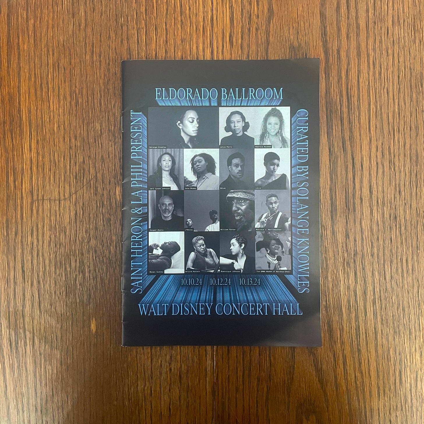 Black and blue pamphlet lying flat on a dark wooden table. The pamphlet reads: Saint Heron and LA Philharmonic Present: El Dorado Ballroom Curated by Solange Knowles. October 10 through 13, 2024 Walt Disney Concert Hall