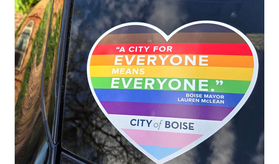Heart-shaped sticker with the multi-colored stripes of the Pride/Progress rainbow flag. Text in white letters: '"A city for EVERYONE means EVERYONE" — Boise Mayor Lauren McLean.' Text in black letters on the white stripe: 'City of Boise.'