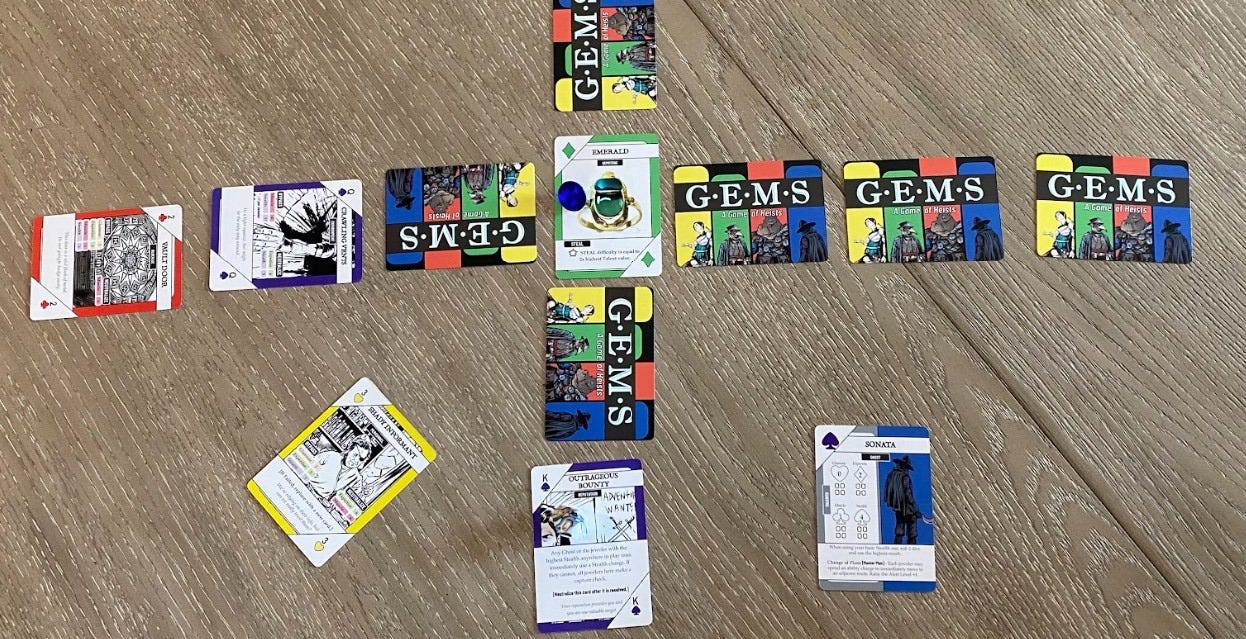 A sample of the playfield of GEMS. 4 routes of cards extend from a central Gemstone card.