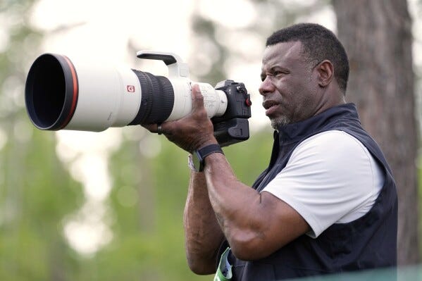 Former MLB great Ken Griffey Jr. takes photos on the 12th hole during the second round at the Masters golf tournament, Friday, April 11, 2025, in Augusta, Ga. (AP Photo/Ashley Landis)