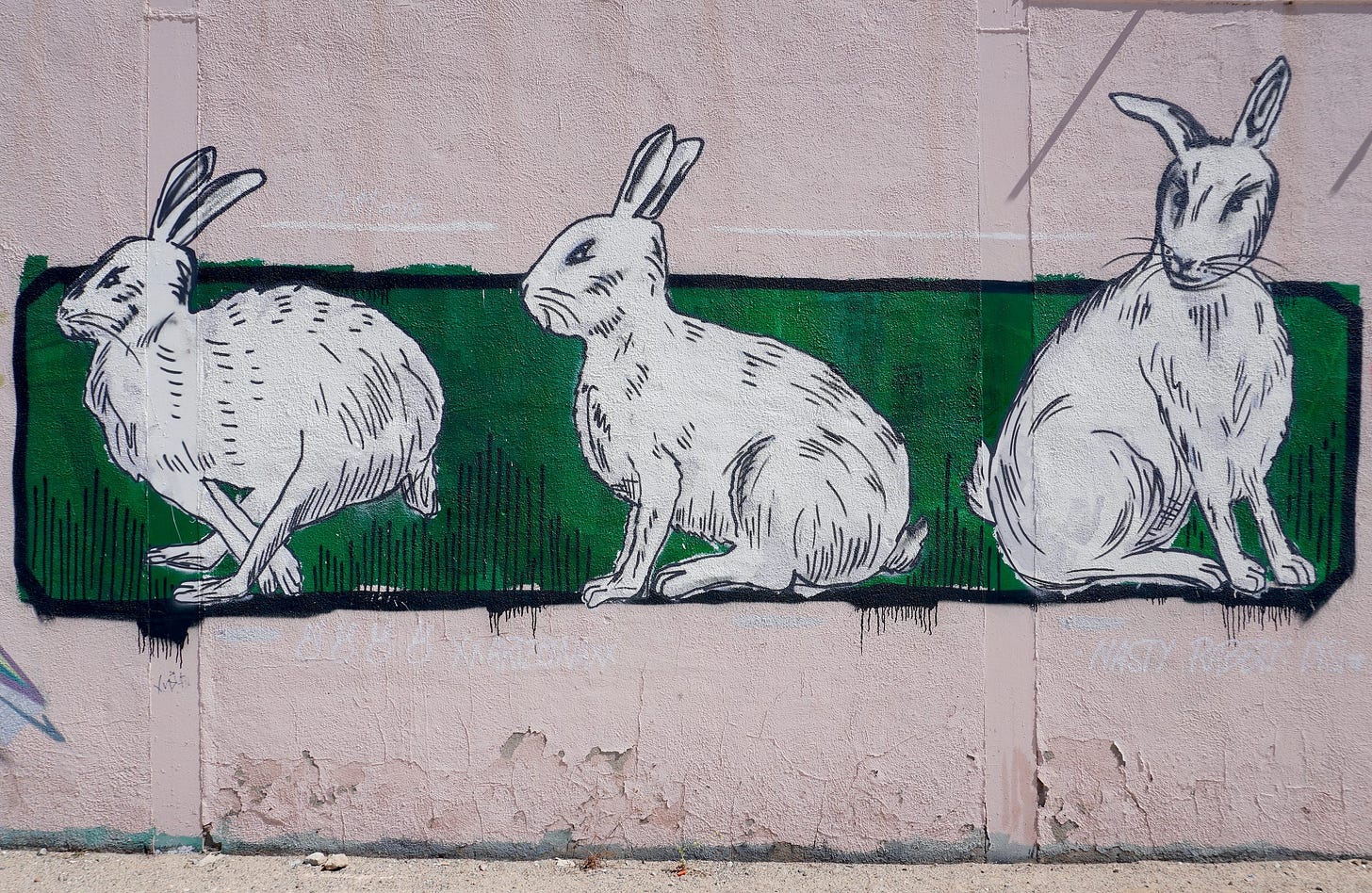 three white rabbits painted on a wall