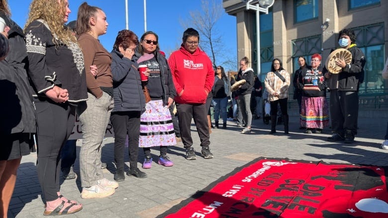 People standing beside a large blanket that says "Dale Culver."