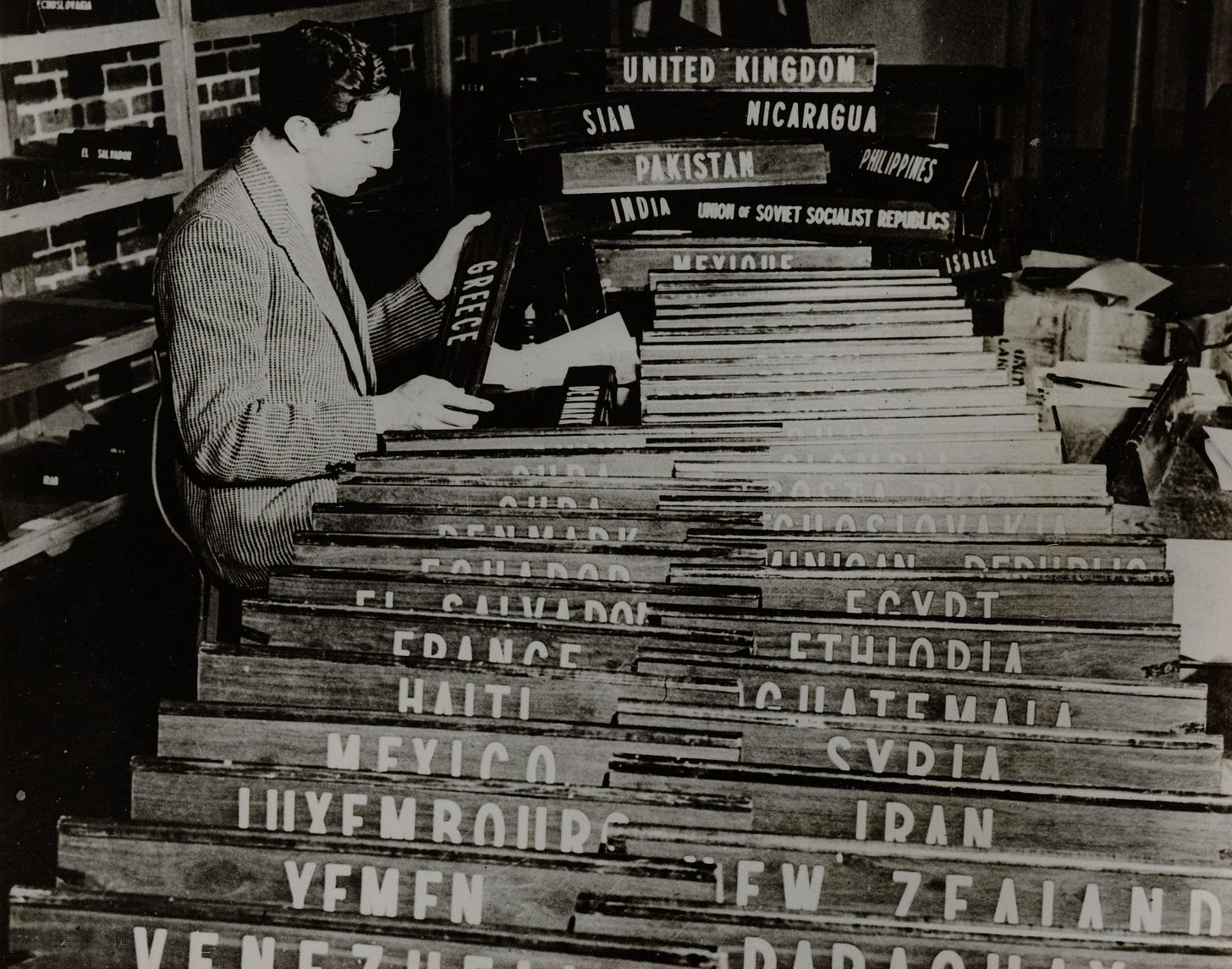 A person preparing name plates for different countries.