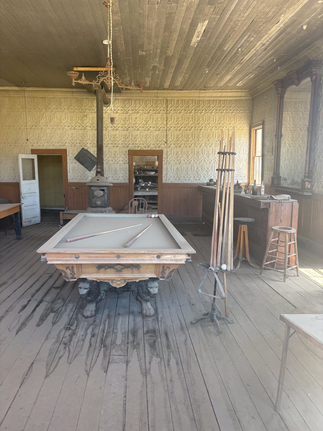 interior of a saloon with pool table in decaying state