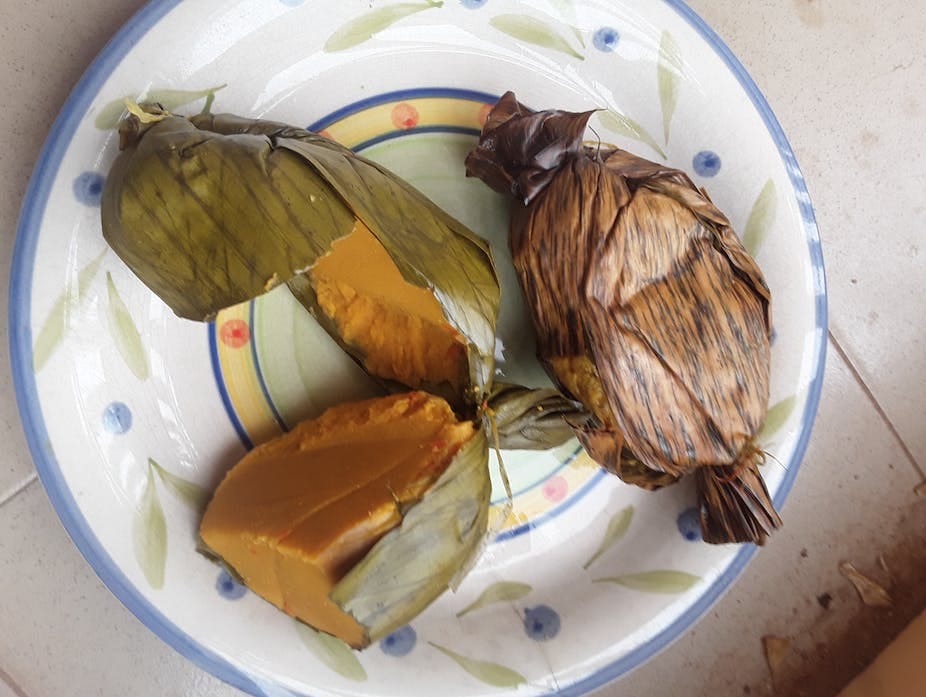 Food wrapped in leaves on a plate.