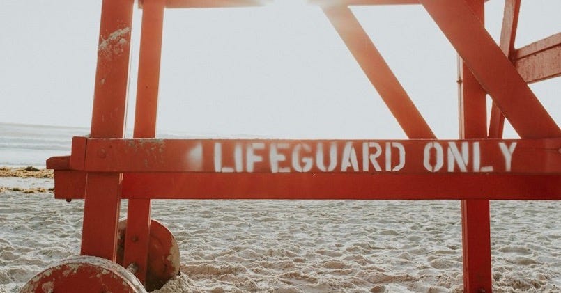 red lifeguard post near shoreline during daytime red lifeguard post near shoreline during daytime