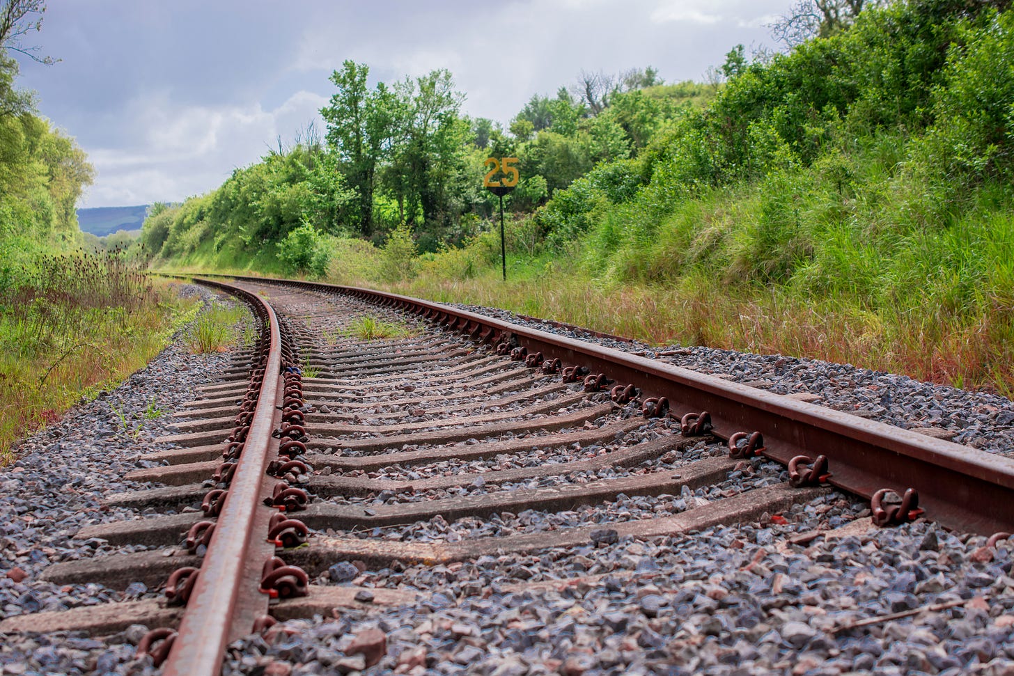 Railway tracks heading into a bend in a rural setting.