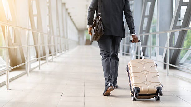 African American businessman in suit walking through airport terminal with suitcase African American businessman in suit walking through airport terminal with rolling luggage. Concept of travel, business trip, mobility and global transportation Business Travel stock pictures, royalty-free photos & images African American businessman in suit walking through airport terminal with suitcase African American businessman in suit walking through airport terminal with rolling luggage. Concept of travel, business trip, mobility and global transportation Business Travel stock pictures, royalty-free photos & images