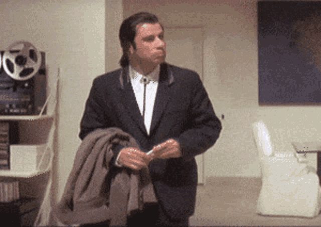 a man in a suit and tie stands in a room a man in a suit and tie stands in a room