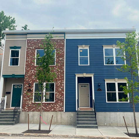 Exterior photos of new townhouses from the street and from the backyard. Several interior photos of a first floor with an open layout.
