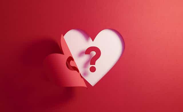 Illustration of cutout of heart from red paper with question mark in its center Illustration of cutout of heart from red paper with question mark in its center