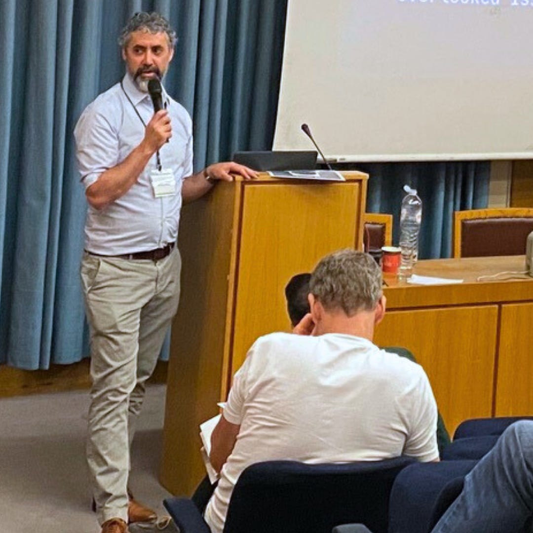 Image of OTI Founder Andrew Hartz speaking to an audience in Athens, Greece