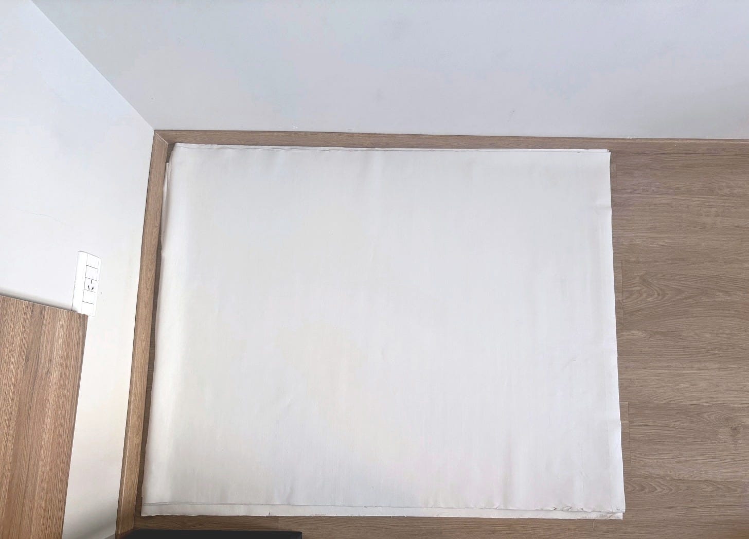 white canvas laid out on laminate floor, unrolled post-travel