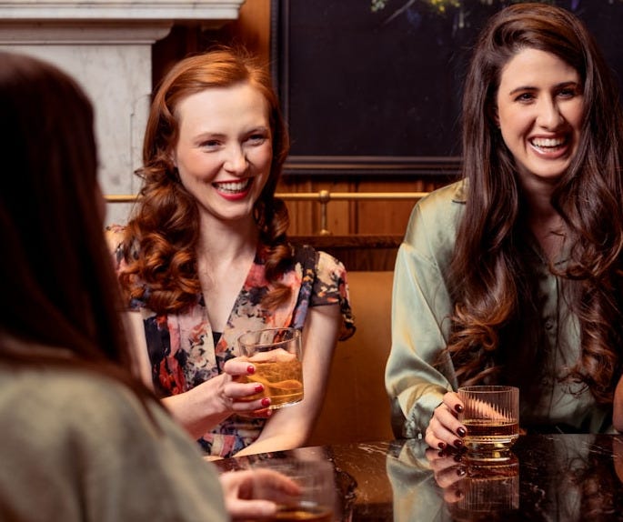 a group of people sitting around a table with drinks