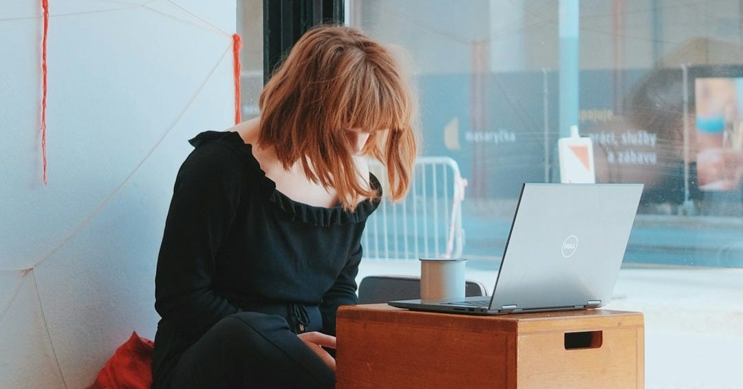 a person sitting at a desk with a laptop