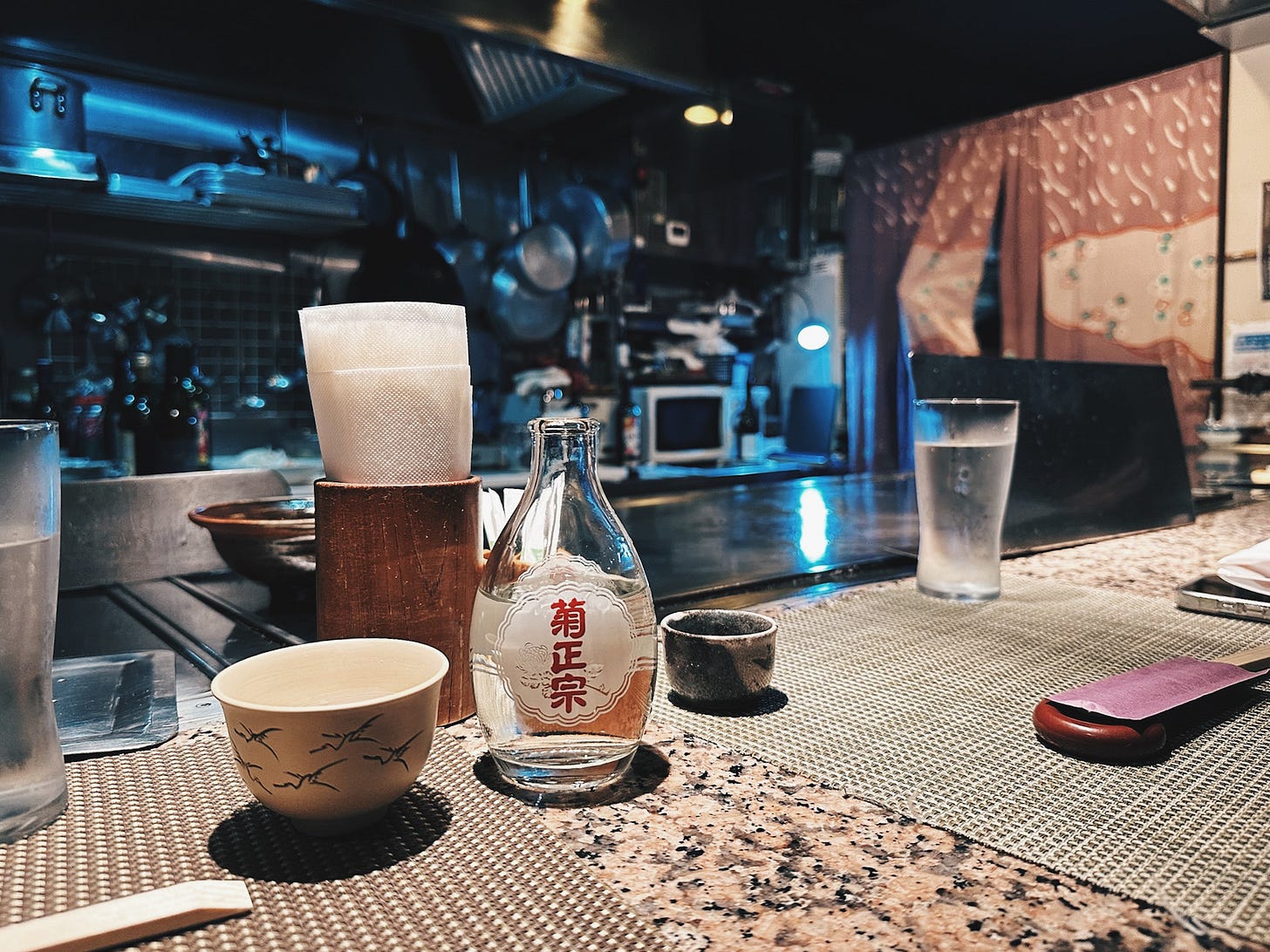 Intimate teppanyaki counter at Kokobu restaurant with sake bottles and chef's workspace, Kobe Japan Intimate teppanyaki counter at Kokobu restaurant with sake bottles and chef's workspace, Kobe Japan