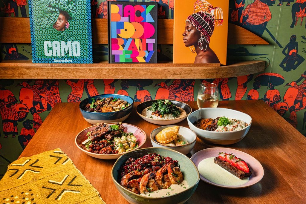 A spread of ChopnBlok dishes in front of a bookcase featuring vibrant coffee table books.