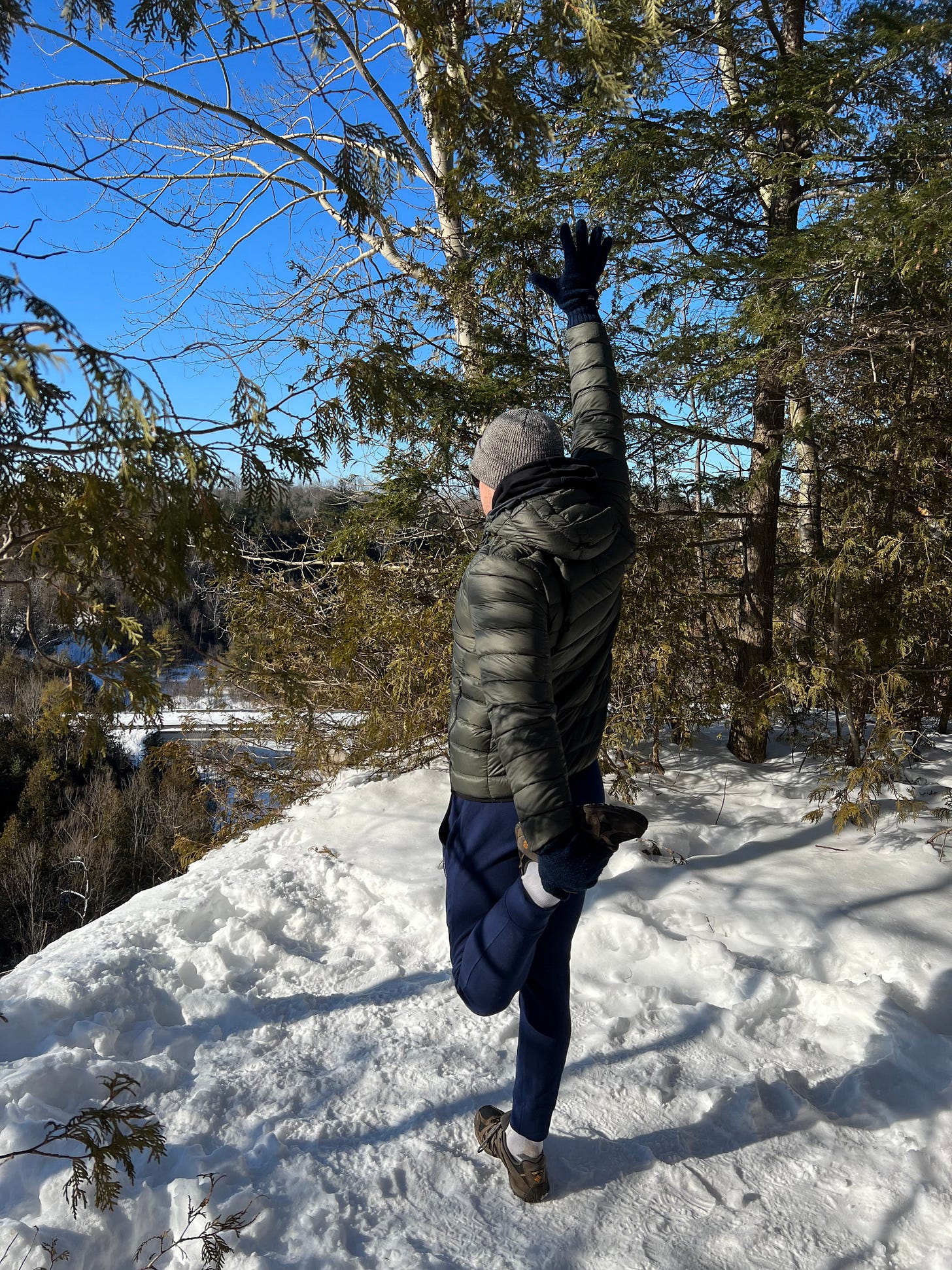 Stretching on the edge of a cliff mid-hike. The Seaton Trail, ON, Canada. January 2022. Stretching on the edge of a cliff mid-hike. The Seaton Trail, ON, Canada. January 2022.