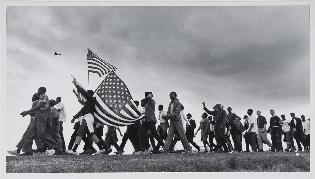 a line of marchers, some carrying American flags, in the Selma to Montgomery March of 1965 a line of marchers, some carrying American flags, in the Selma to Montgomery March of 1965