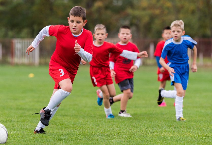 young children playing soccer