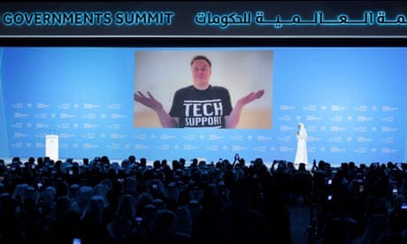 a man on screen in front of a crowd