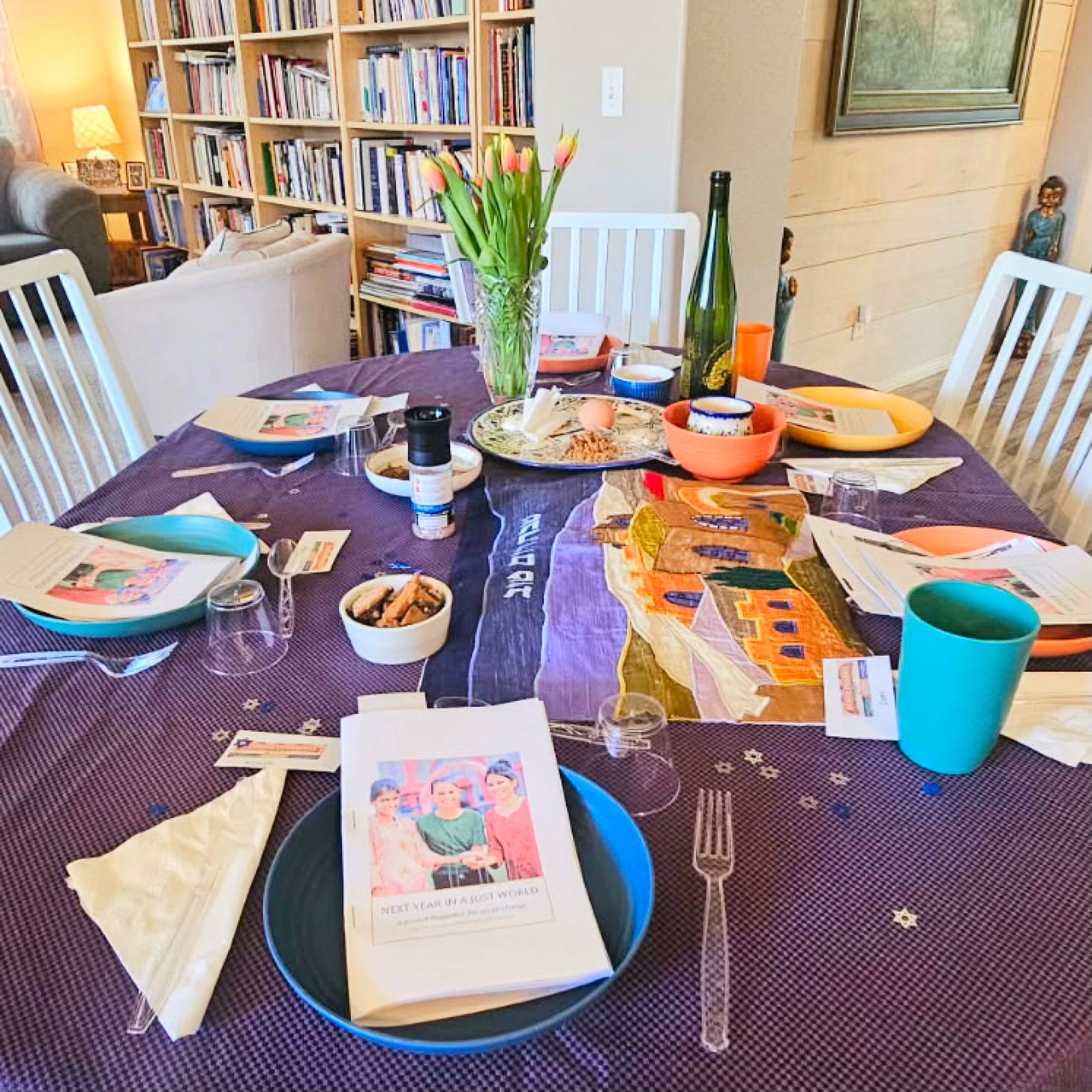The Soul Food Pot® cultural storytelling moment—an intimate Passover Seder table set in a Las Vegas home with Haggadah booklets, ceremonial plate, wine, and spring tulips, where community leaders gather to share Jewish traditions through food, history, and conversation.