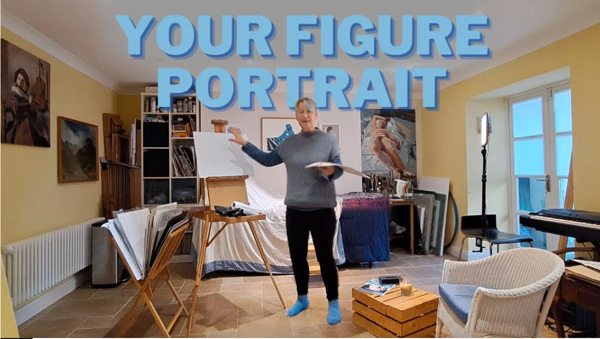 Gail in her studio, in front of her easel, with a bed set up for a model behind her, and a comfortable chair to the side