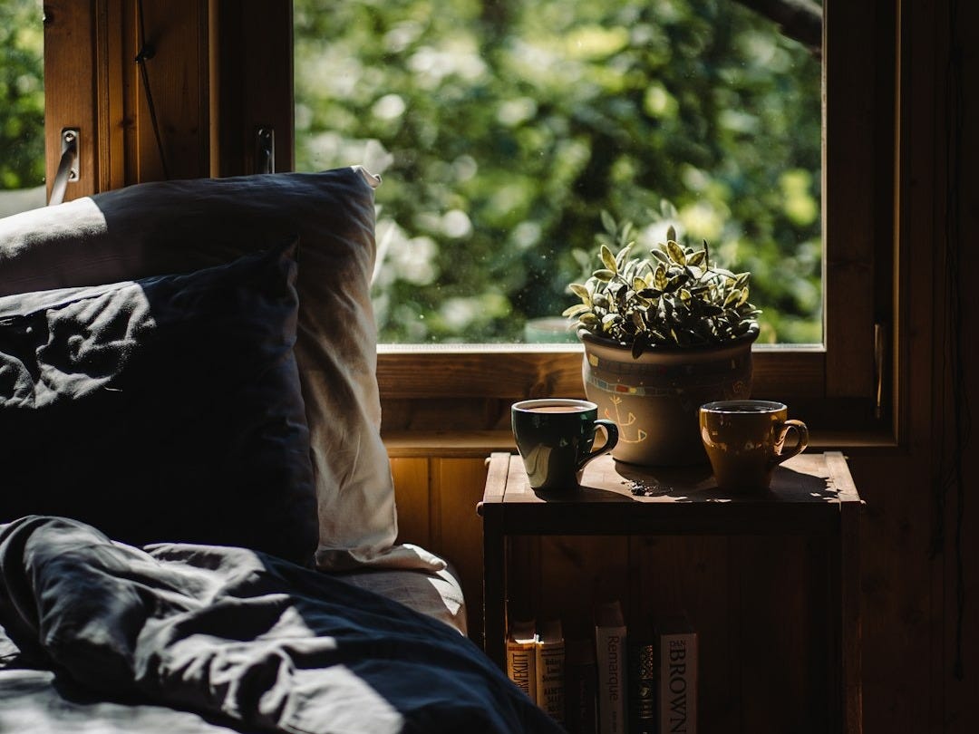 a bed sitting in a bedroom next to a window