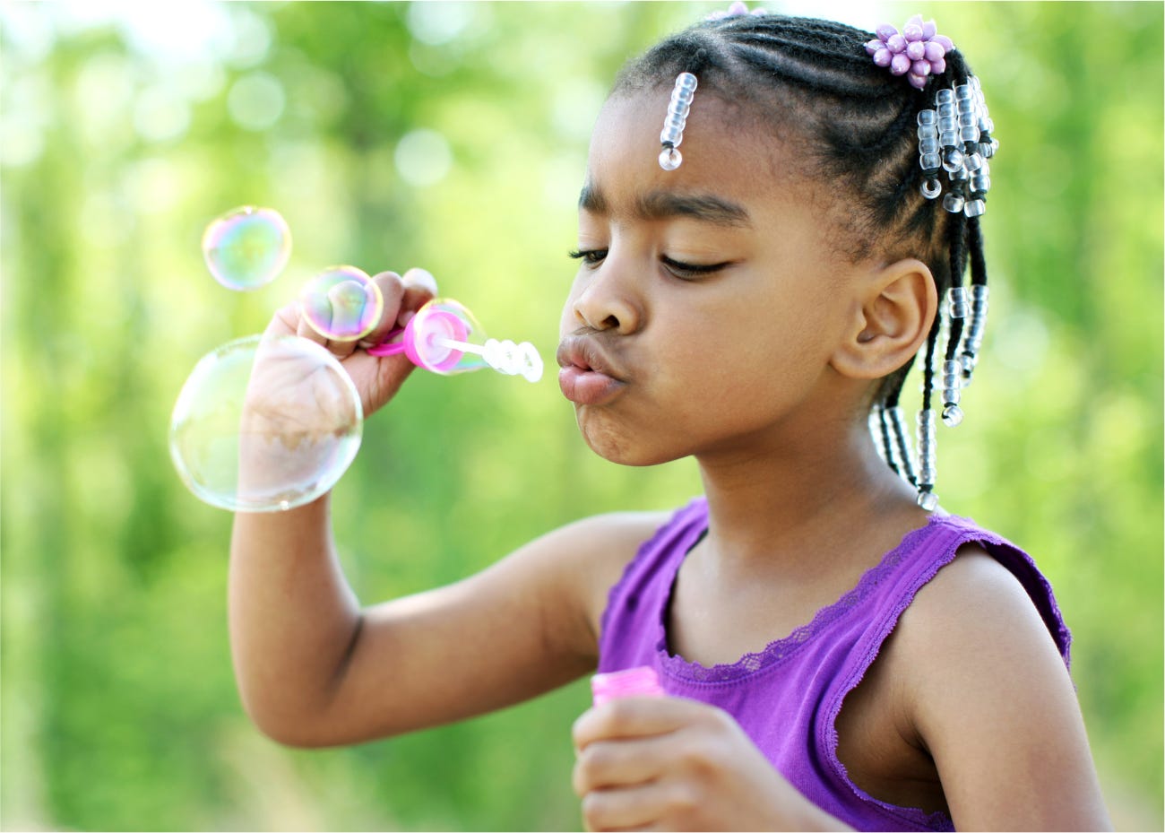 child blowing bubbles outside