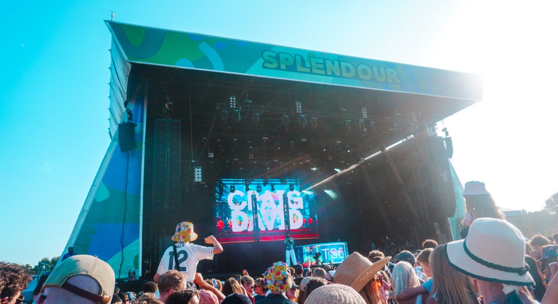 A stage with a crowd of people in front of it and a screen that says 'Craig David' A stage with a crowd of people in front of it and a screen that says 'Craig David'